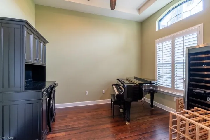 Home office with dark hardwood / wood-style flooring
