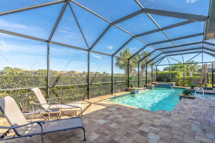 View of swimming pool featuring a lanai, an in ground hot tub, and a patio