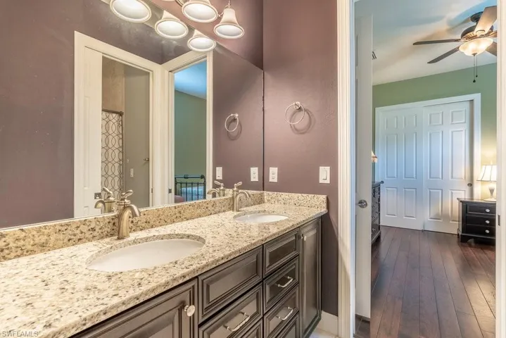 Bathroom with hardwood / wood-style floors, vanity, and ceiling fan