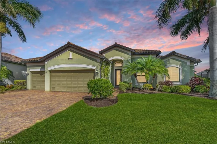 Mediterranean / spanish-style home featuring a lawn and a garage