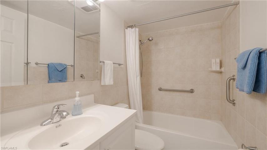 Guest bath has custom tile throughout, higher toilet & vanity, tri-way mirrored medicine cabinet.