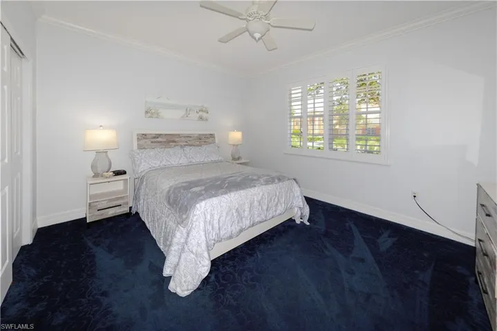 Spacious guest bedroom features Plush carpet, Crown molding, large window with Plantation shutters, ample closet space & wide baseboards.