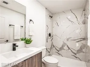 Bathroom featuring vanity and a marble style finish shower