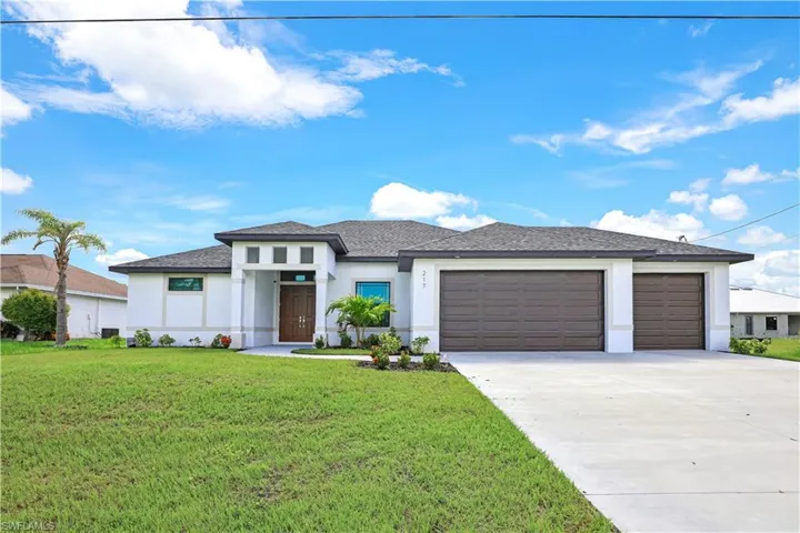 Prairie-style home with an attached garage, stucco siding, concrete driveway, a front yard, and roof with shingles