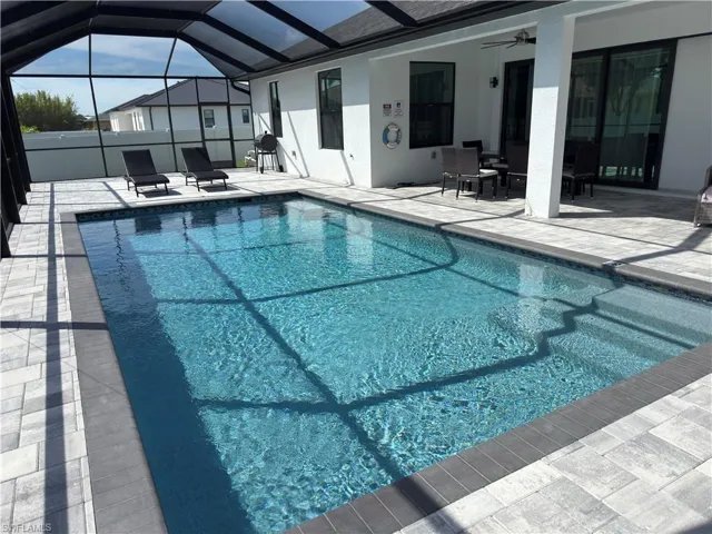 Swimming pool featuring a patio, a sunroom, ceiling fan, and a lanai