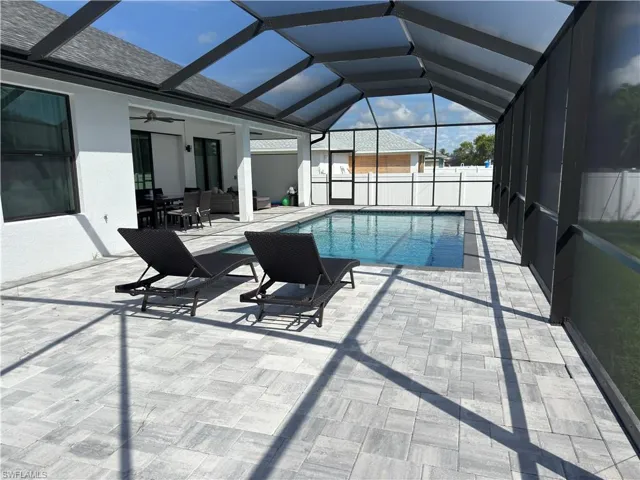 View of pool with a ceiling fan, a sunroom, a lanai, and a patio area