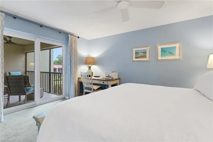 Carpeted bedroom with access to exterior and ceiling fan