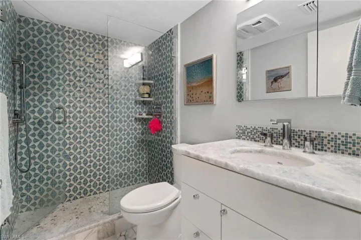 Full bath featuring vanity and a tile shower