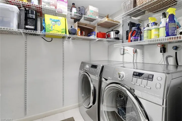 Laundry area featuring washer and dryer and light tile patterned floors