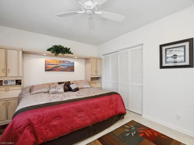 Bedroom featuring ceiling fan, a closet, and light carpet