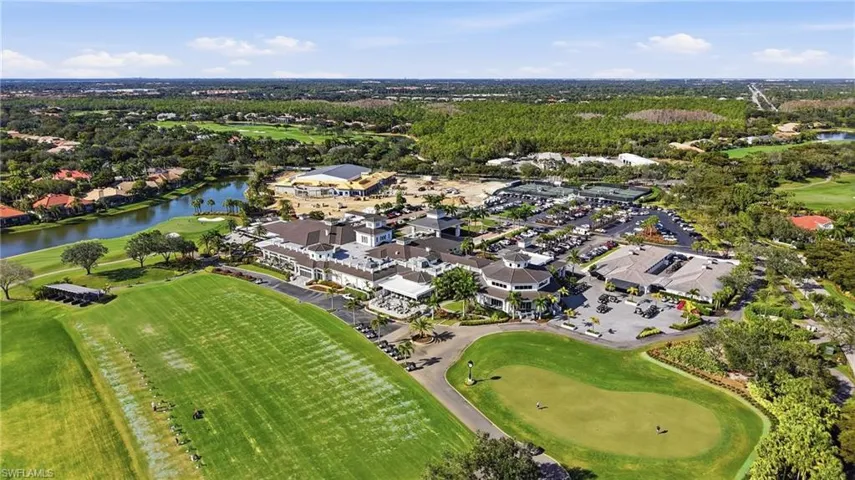 Aerial view of property and surrounding area with a local golf course, a large body of water, and nearby suburban area