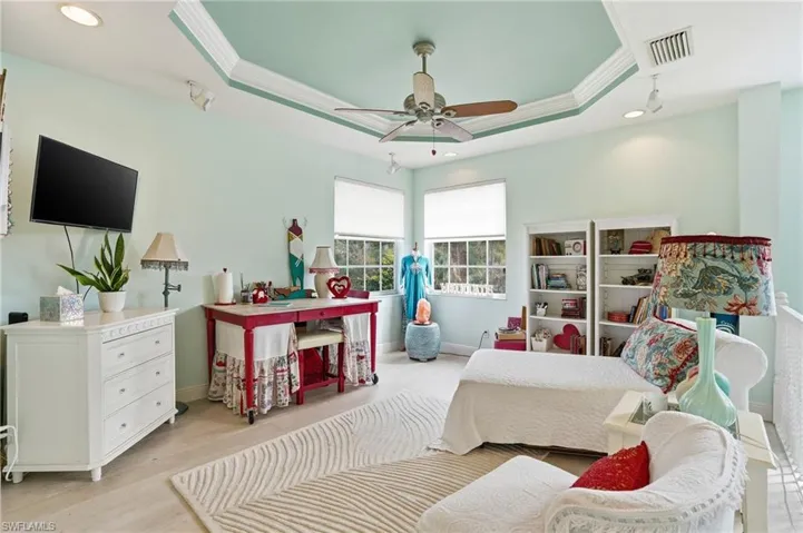 Bedroom with recessed lighting, wood finished floors, a ceiling fan, crown molding, and a tray ceiling