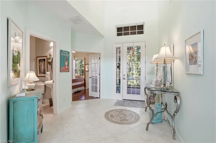 Entrance foyer with light tile patterned floors, a high ceiling, and healthy amount of natural light