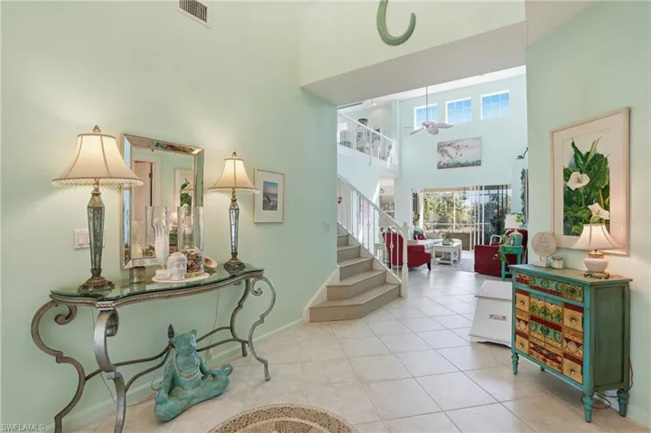 Entryway with tile patterned floors, a high ceiling, and ceiling fan