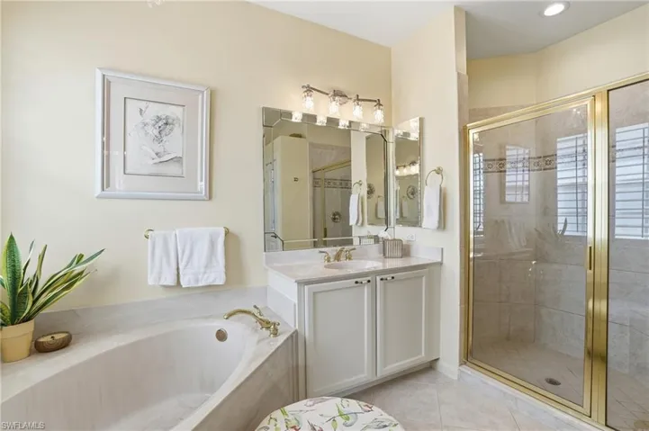 Full bathroom with a shower stall, vanity, a garden tub, and light tile patterned floors