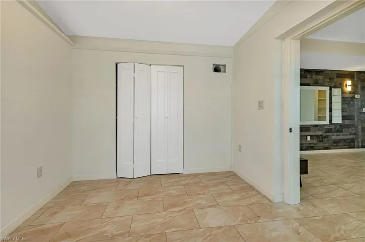 Unfurnished bedroom featuring a closet and light tile floors
