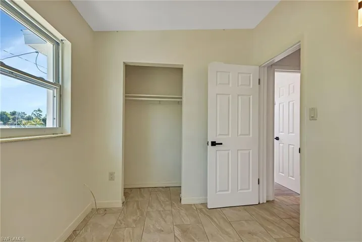 Unfurnished bedroom with a closet and light tile floors