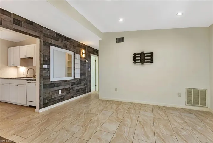 Unfurnished living room with sink and light tile flooring