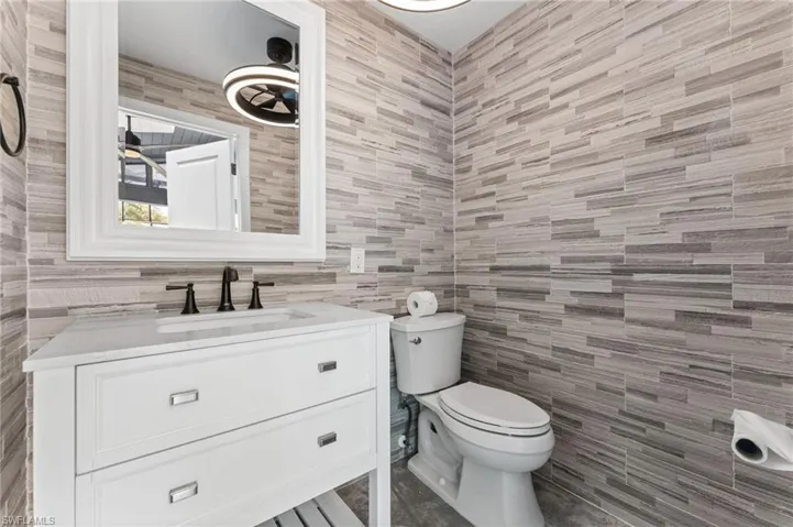 Bathroom featuring tile walls and vanity