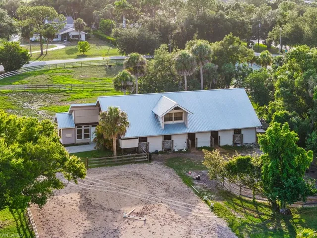 Aerial view of property and surrounding area featuring a tree filled landscape