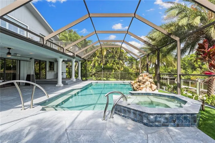 View of pool with a patio, a lanai, a pool with connected hot tub, and a ceiling fan