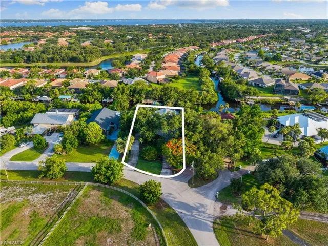 Aerial view of residential area featuring property parcel outlined and a large body of water