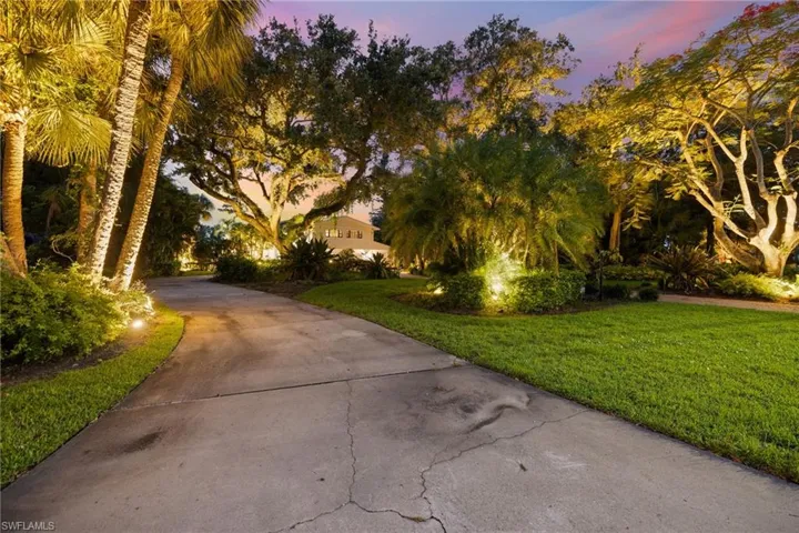 View of property's community with a yard and concrete driveway