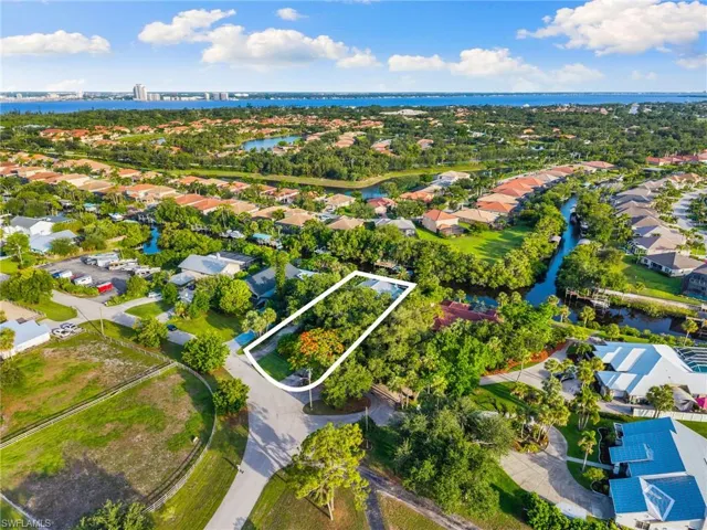 Aerial perspective of suburban area featuring a large body of water and property parcel outlined