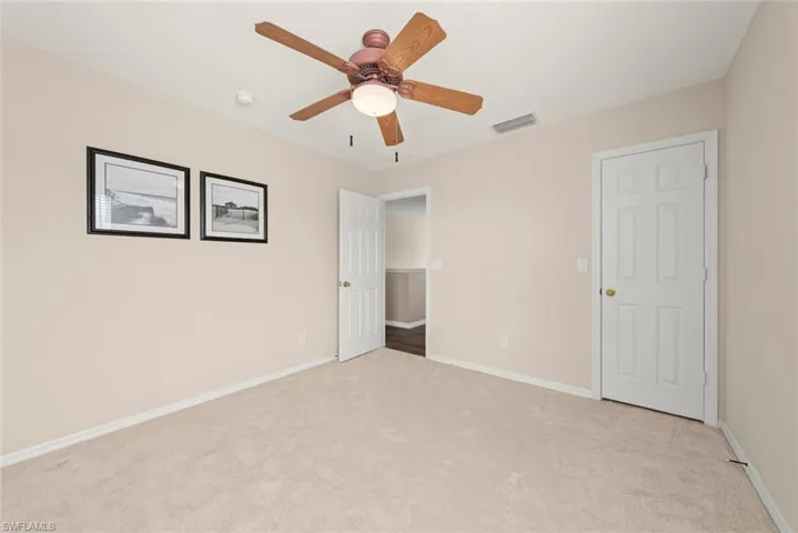 Unfurnished bedroom #2 with light colored carpet and a ceiling fan