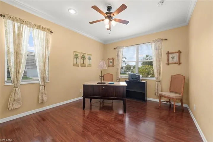 Office, library, or den area with laminate floors, a ceiling fan, baseboards, crown molding, and recessed lighting