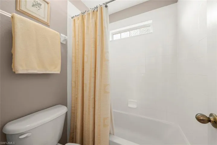 Full bathroom upstairs featuring toilet and shower / tub combo
