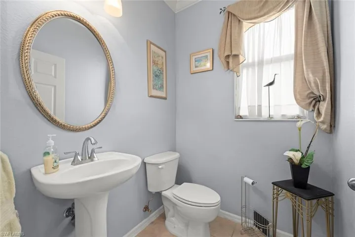 Bathroom on first floor with toilet, sink, and tile patterned floors