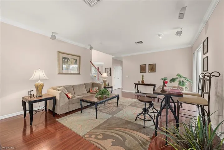 Family room with crown molding, laminate floors, and baseboards