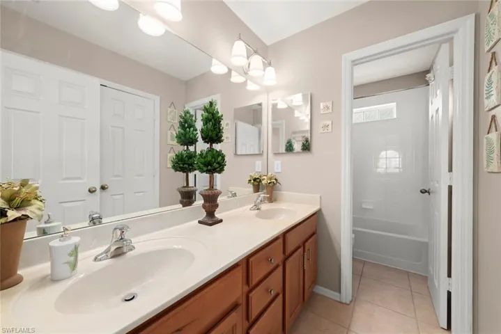 Full bath upstairs with tile patterned flooring, double vanity, a toilet, and shower and bathtub combination
