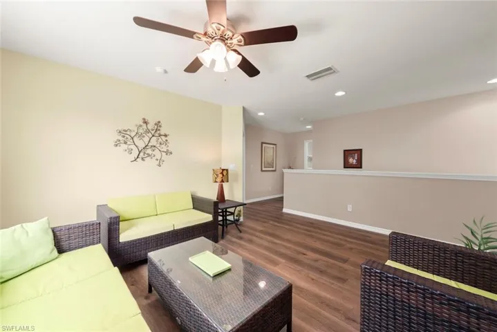 Upstairs flex space for a den, office, play area, family room, or whatever you want featuring laminate floors, a ceiling fan, and a plenty of natural light