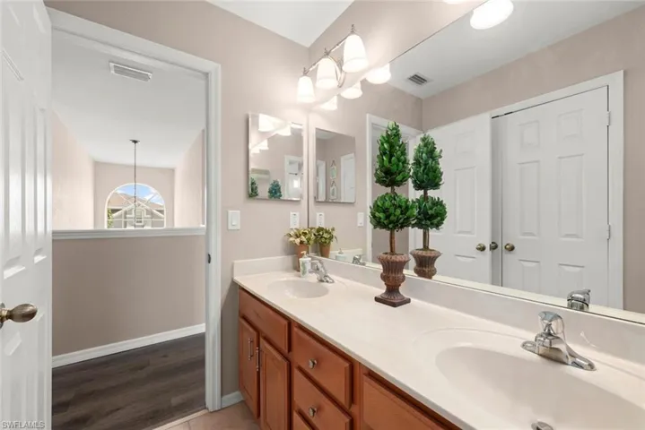 Full bathroom upstairs featuring double vanity and laminate flooring