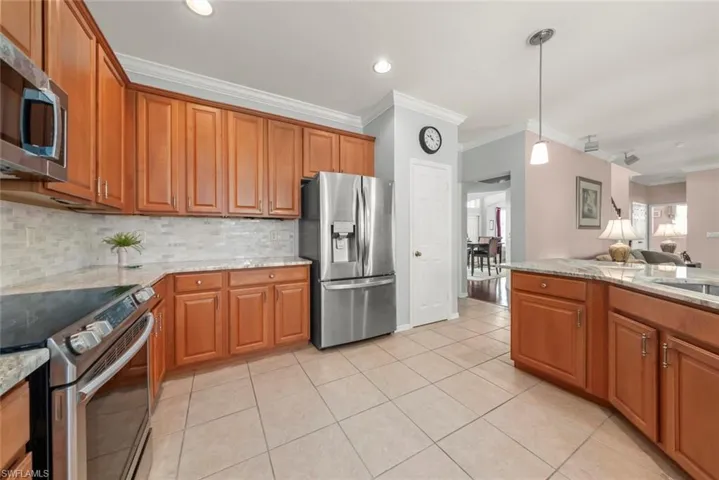 Kitchen featuring stainless steel appliances, crown molding, plenty of cabinet space, pantry, decorative backsplash, and recessed lighting
