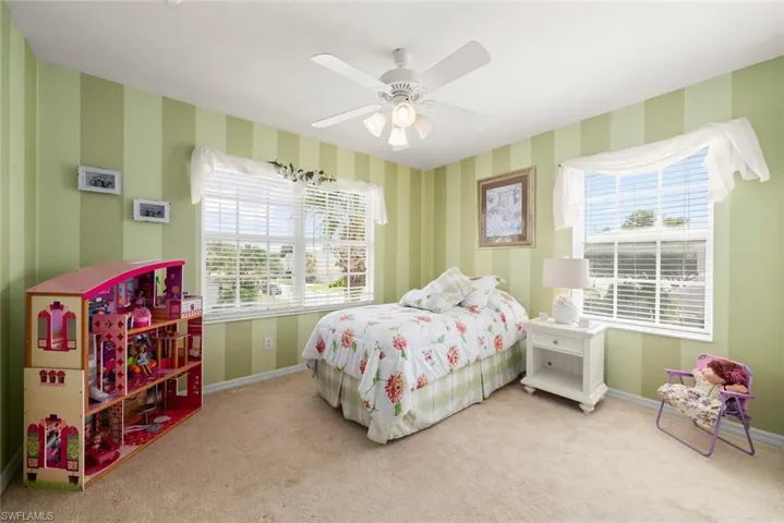 Bedroom #1 with carpet, ceiling fan, and multiple windows