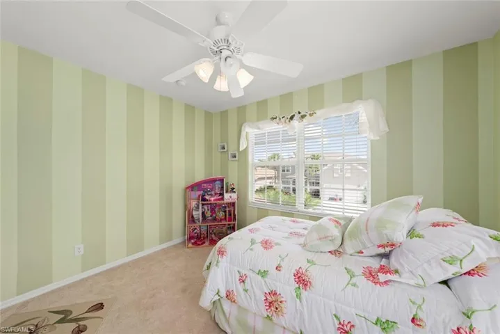 Carpeted bedroom #1 featuring a ceiling fan and window