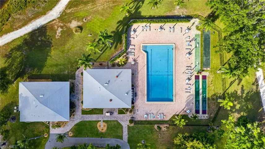 Community pool area featuring a rectangular swimming pool, surrounding patio, and lounge seating