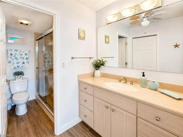 Bathroom vanity with integrated sink, light-toned countertop, and ample storage cabinetry