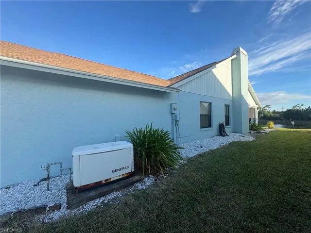 View of home's exterior featuring a yard, stucco siding, and a chimney