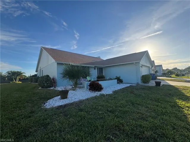 Ranch-style house with a front lawn, an attached garage, stucco siding, and concrete driveway
