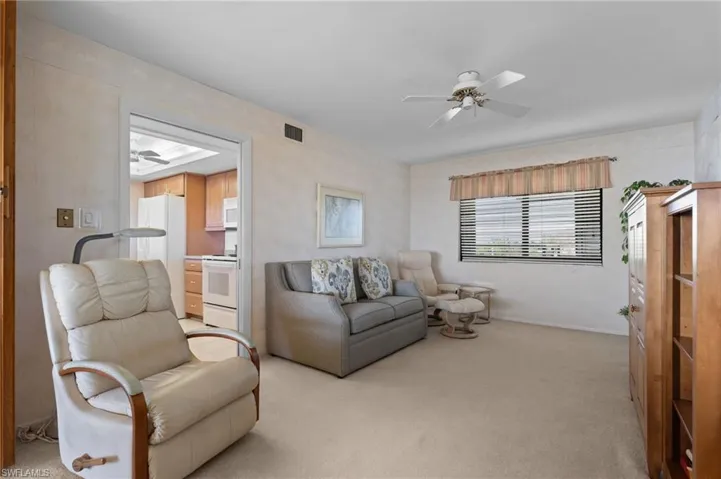 Living room with ceiling fan and light colored carpet