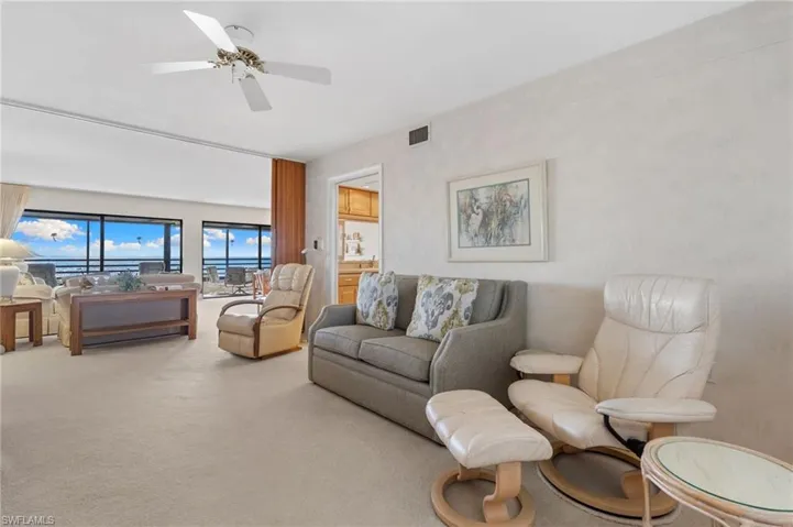 Living room with carpet and a ceiling fan