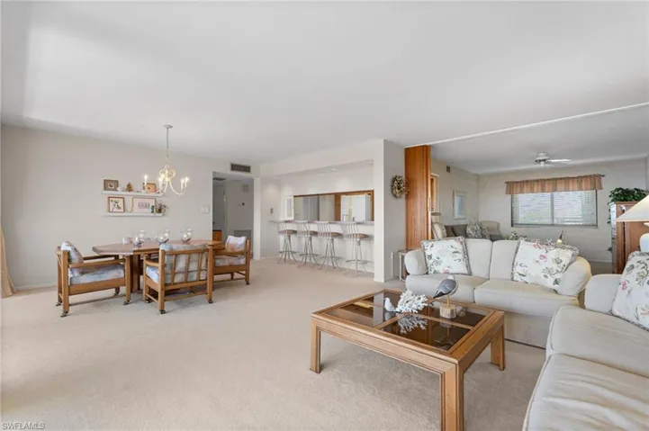 Carpeted living room featuring a chandelier