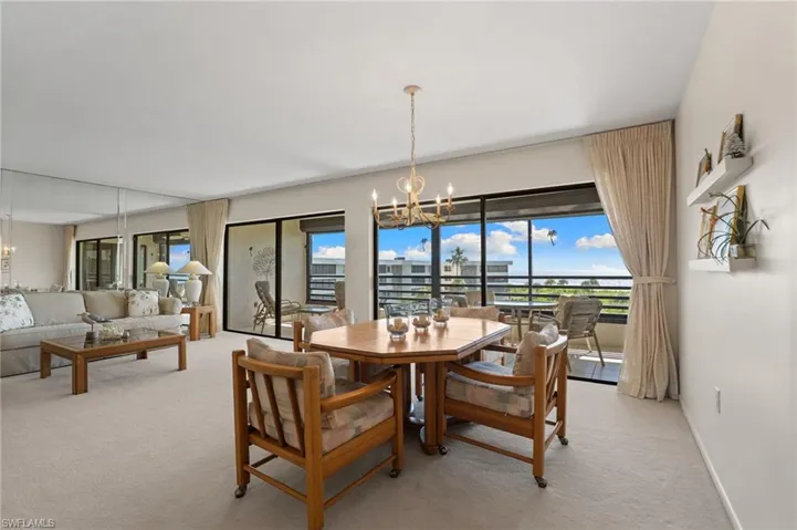 Dining area with a chandelier and light carpet