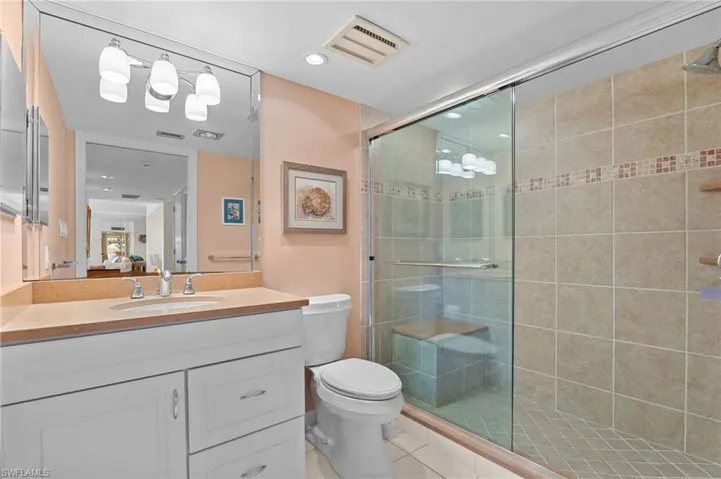 Bathroom featuring vanity, a shower stall, recessed lighting, and light tile patterned flooring