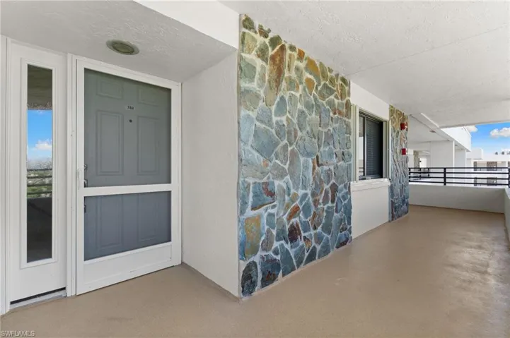 Entrance to property featuring stone siding