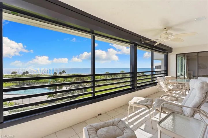 Sunroom / solarium with tile patterned floors and a water view